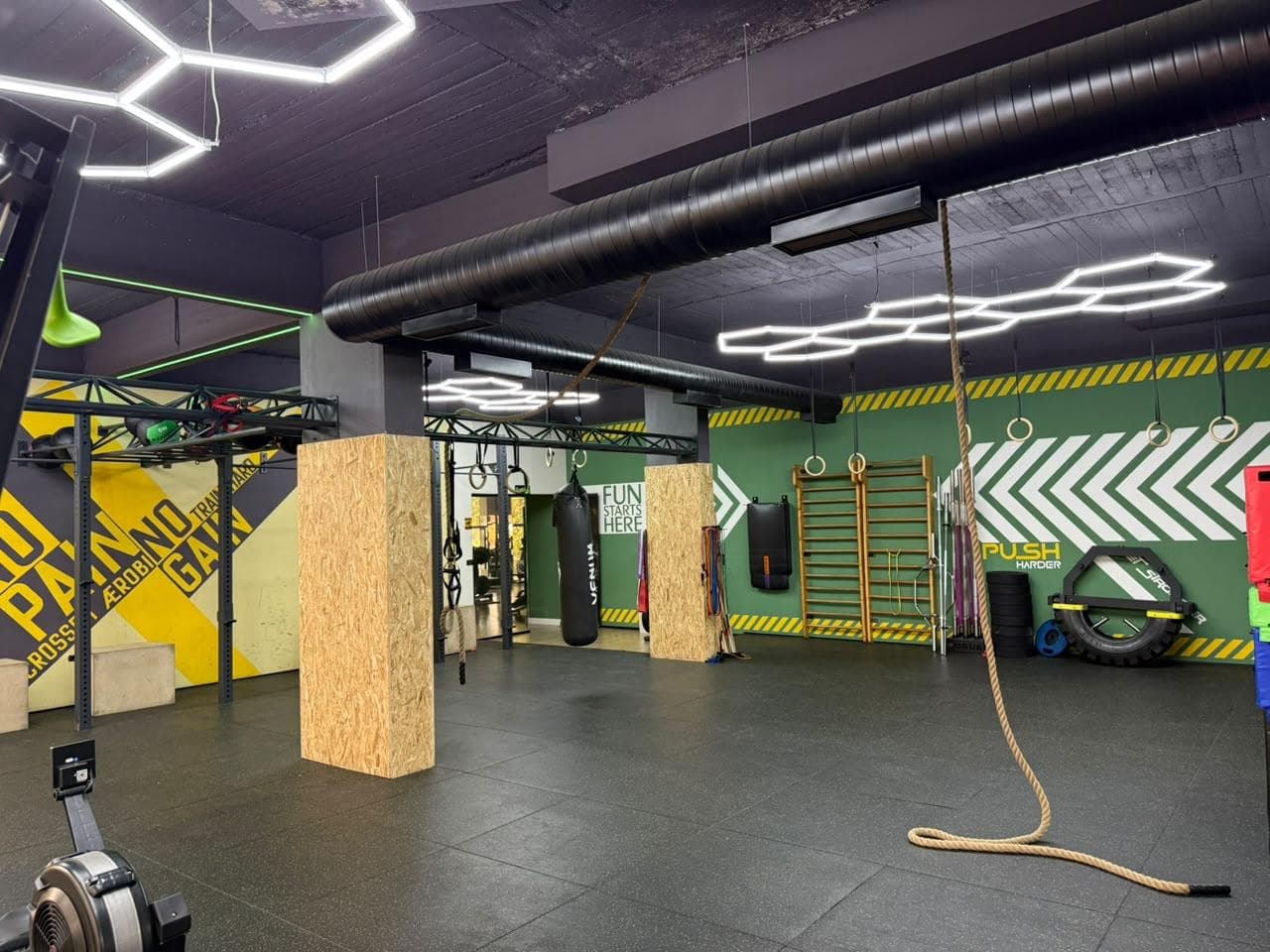 A corridor of the crossfit zone lined with wooden plyo blocks and a hanging punching bag