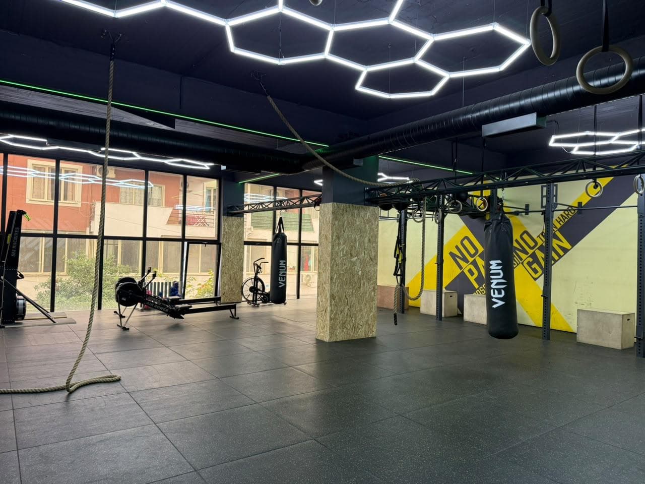 A battle rope, rowing machine and air bike set up on the functional training floor
