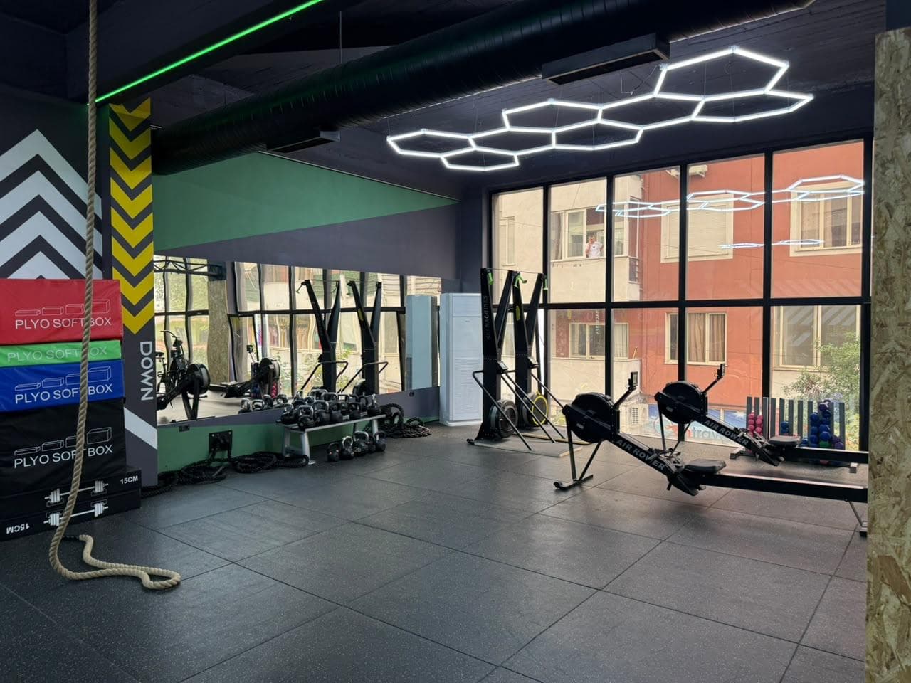 Plyo boxes, a battle rope and rowing machines along the mirrored training wall