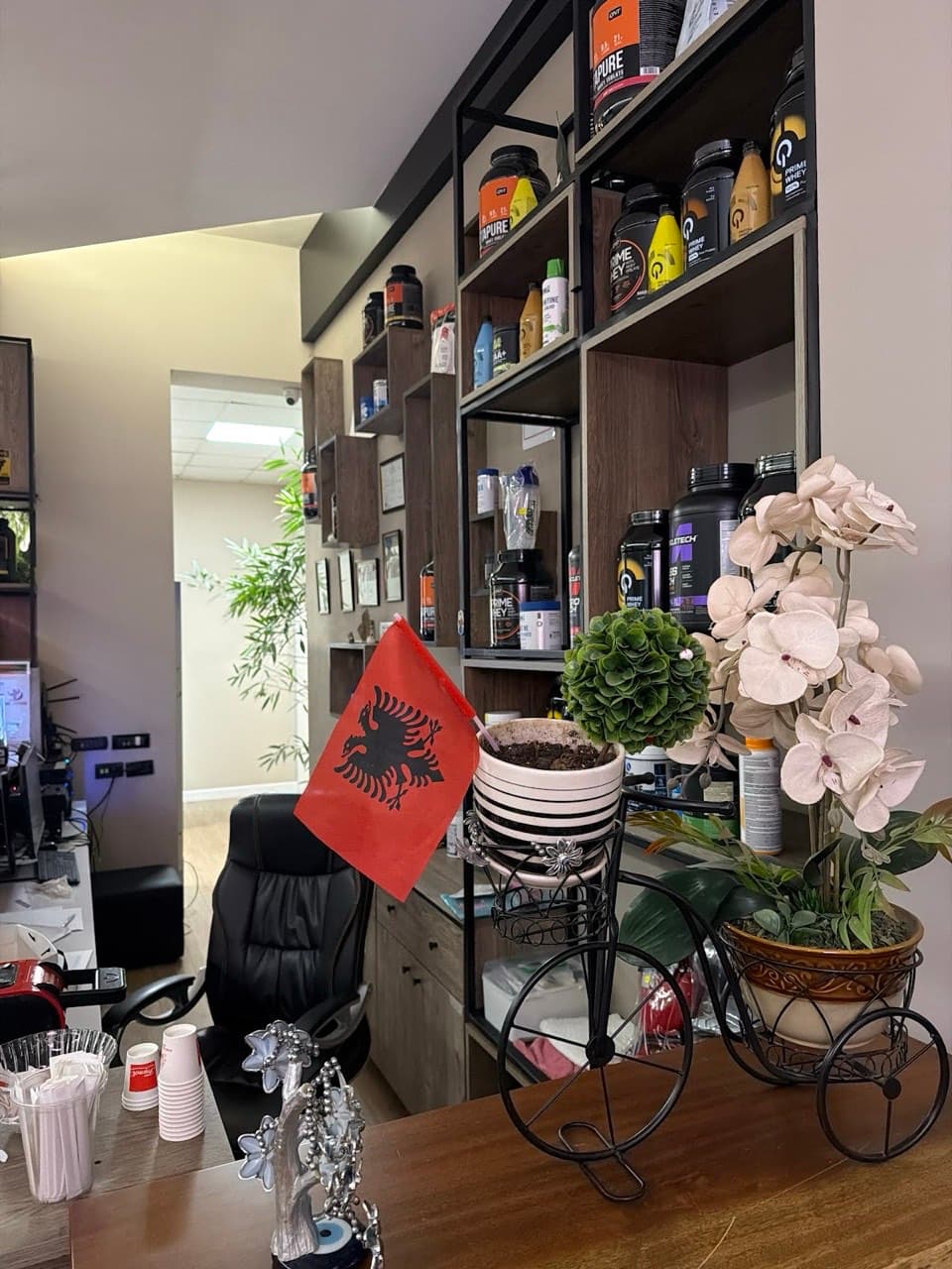 A shelf of protein tubs and supplements beside the front desk seating area